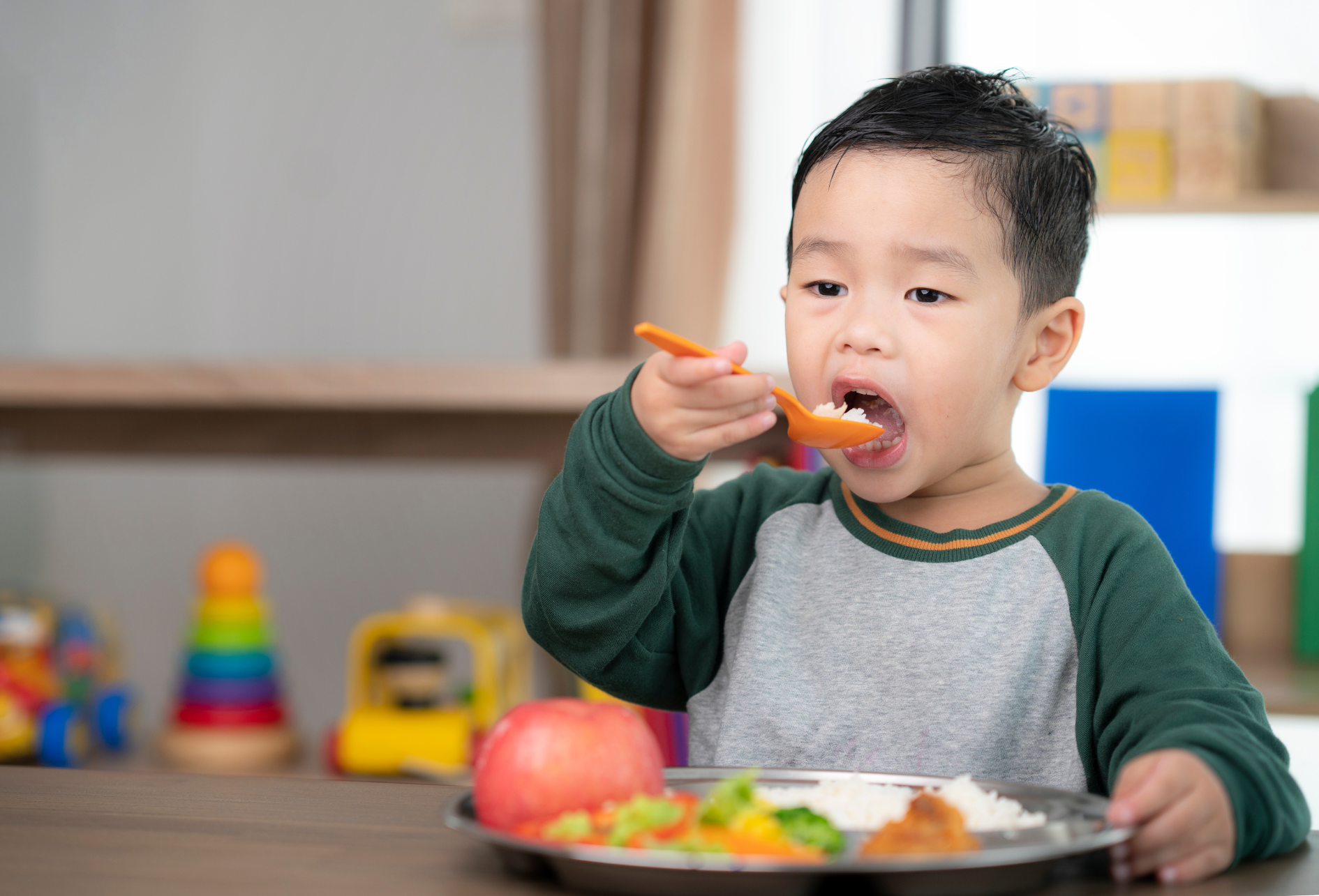 A cheerful boy enjoying a bowl of rice, smiling brightly to show his healthy teeth, highlighting the joy of eating nutritious meals.